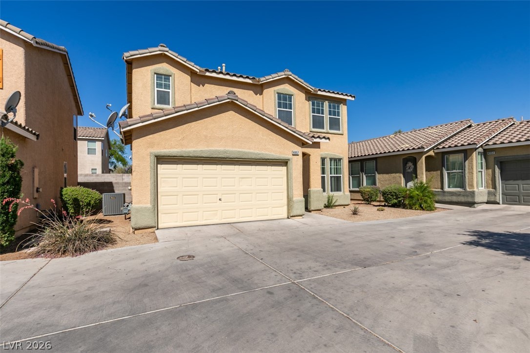 4957 Miners Ridge Drive Las Vegas, NV 89122 - Photo 2 of 39 This residence features a tiled roof and an attached garage, offering both style and convenience.