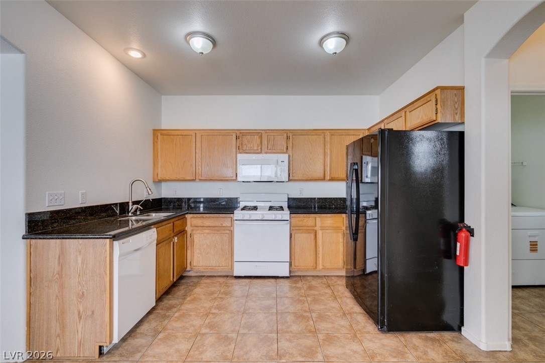 4957 Miners Ridge Drive Las Vegas, NV 89122 - Photo 22 of 39 This functional kitchen features ample cabinetry and dark countertops, offering a practical culinary space.