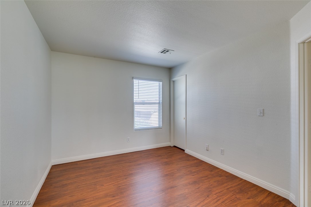 4957 Miners Ridge Drive Las Vegas, NV 89122 - Photo 26 of 39 This spacious room features rich wood flooring, crisp white walls, and a window with natural light.