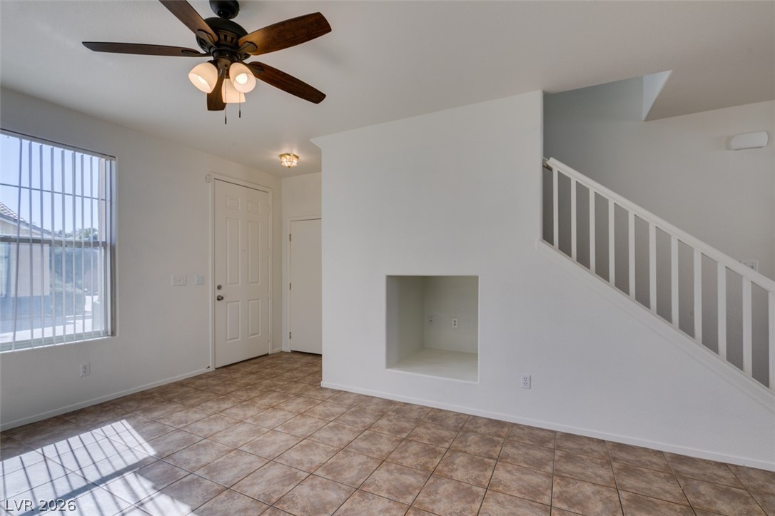 4957 Miners Ridge Drive Las Vegas, NV 89122 - Photo 9 of 39 This inviting space features a ceiling fan, tiled floors, and a bright window, creating a comfortable ambiance.