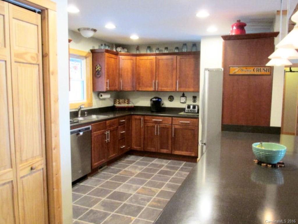 2574 Cabin Flats Road Sylva, NC 28779 - Photo 12 of 22 a kitchen with stainless steel appliances granite countertop a stove a sink and a microwave