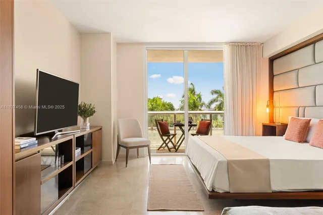 a bedroom with a bed and a flat tv screen on dresser