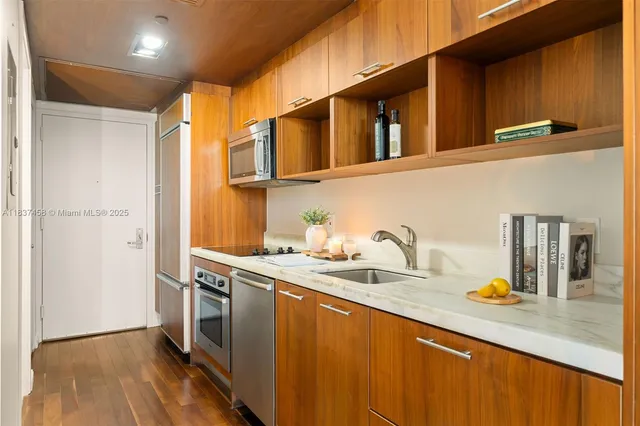a kitchen with stainless steel appliances granite countertop a sink a stove and a refrigerator