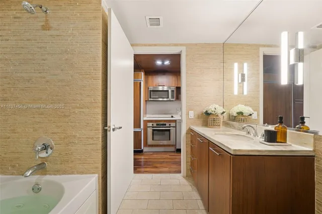 a bathroom with a double vanity sink a mirror and a bathtub