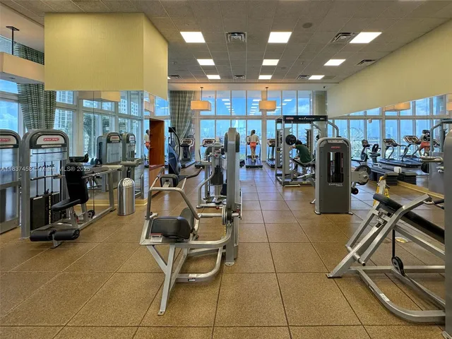 a room with gym equipment and kitchen view