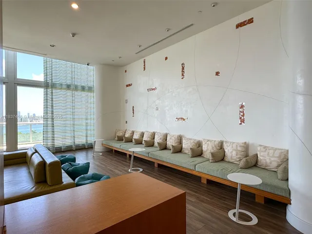 a living room with furniture wooden floor and a large window