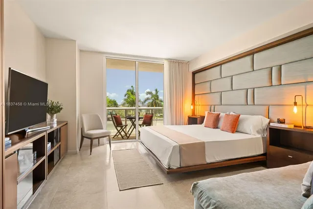 a bedroom with a bed and a flat screen tv on the dresser