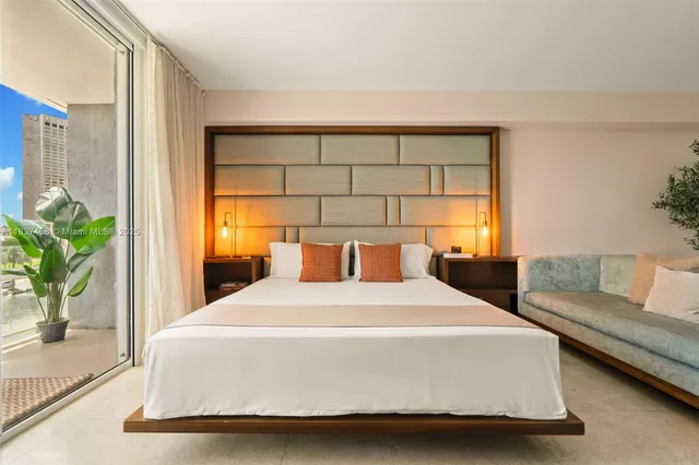 a bedroom with a large bed and a potted plant