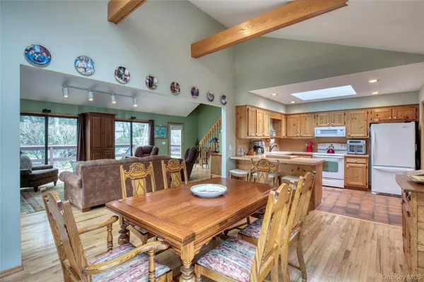 a living room with stainless steel appliances kitchen island granite countertop furniture and a dining table