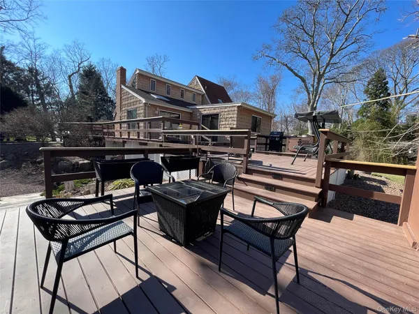 a view of a roof deck with table and chairs with wooden floor and fence