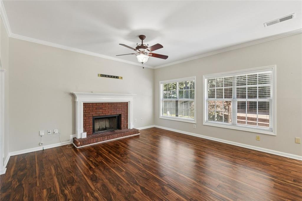 2435 Cobble Creek Lane Grayson, GA 30017 - Photo 11 of 39 a view of an empty room with wooden floor fireplace and a window