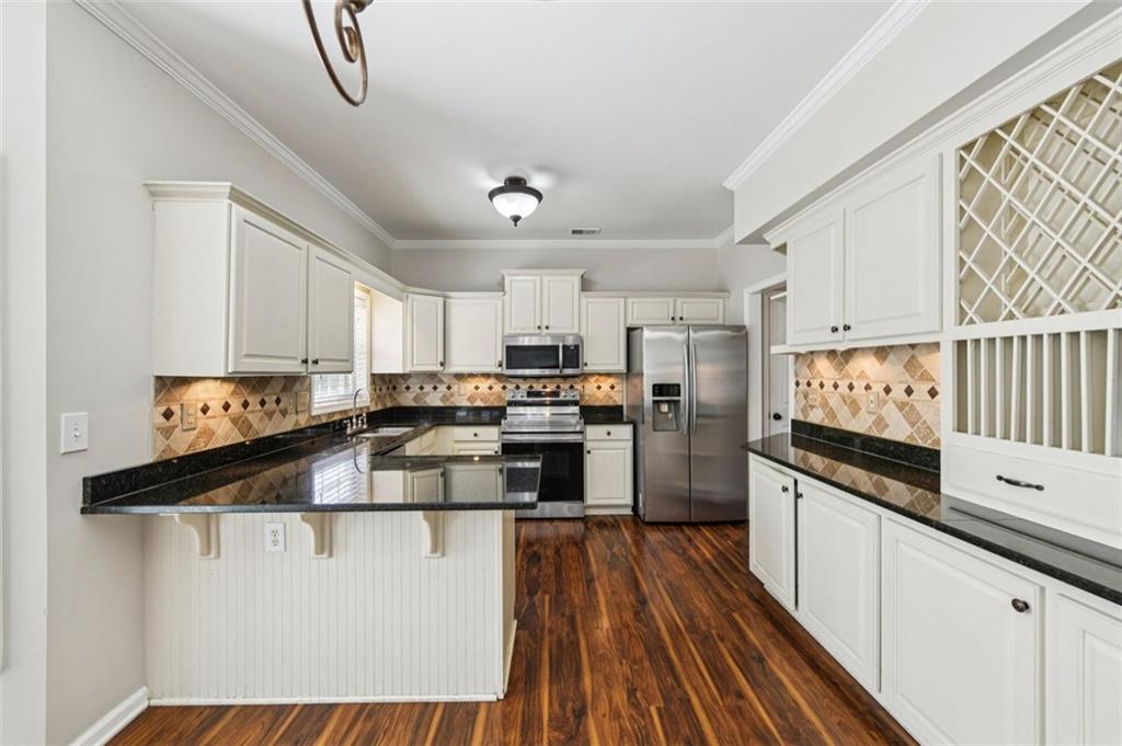 2435 Cobble Creek Lane Grayson, GA 30017 - Photo 19 of 39 a kitchen with granite countertop a sink cabinets and stainless steel appliances