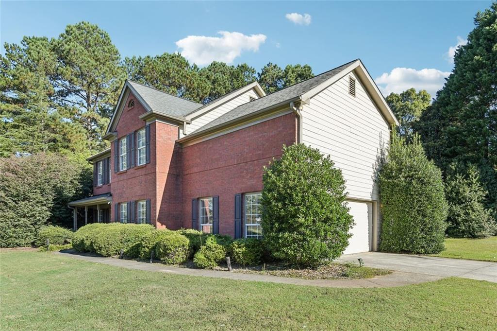 2435 Cobble Creek Lane Grayson, GA 30017 - Photo 2 of 39 a view of a brick house with a yard and plants