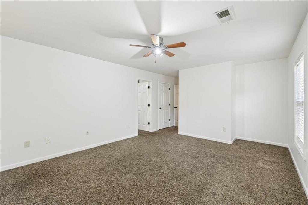 2435 Cobble Creek Lane Grayson, GA 30017 - Photo 34 of 39 an empty room with a ceiling fan and a window