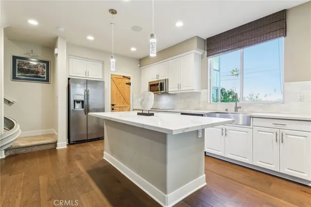 a kitchen with kitchen island a sink stainless steel appliances and cabinets