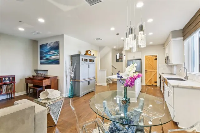 a kitchen with stainless steel appliances kitchen island granite countertop a refrigerator and a dining table