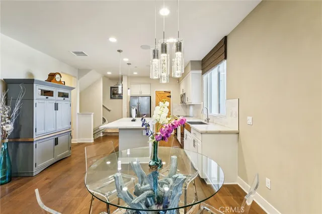 a view of a dining room with furniture a kitchen and chandelier