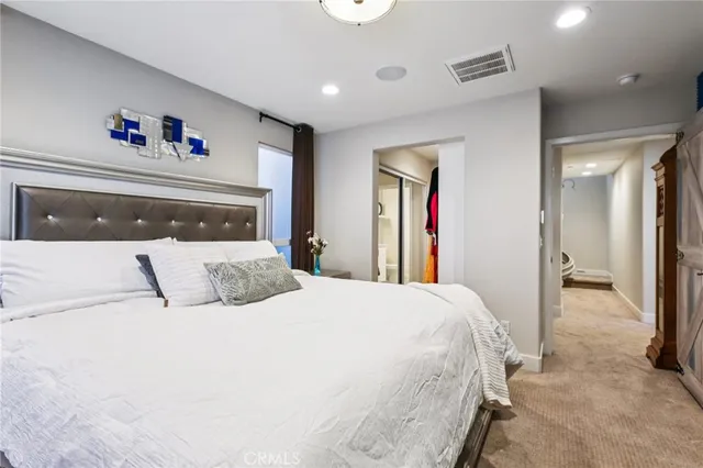 a bedroom with a large bed and a chandelier