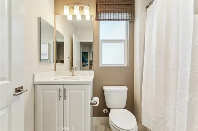 a bathroom with a toilet a sink and a mirror