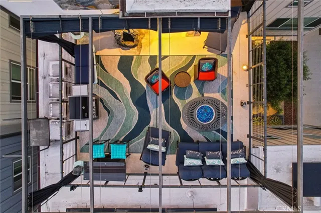 a view of a living room and balcony with furniture and floor to ceiling window