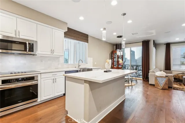 a kitchen with a sink stove and wooden floor