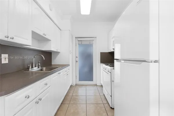 a large kitchen with a sink and refrigerator