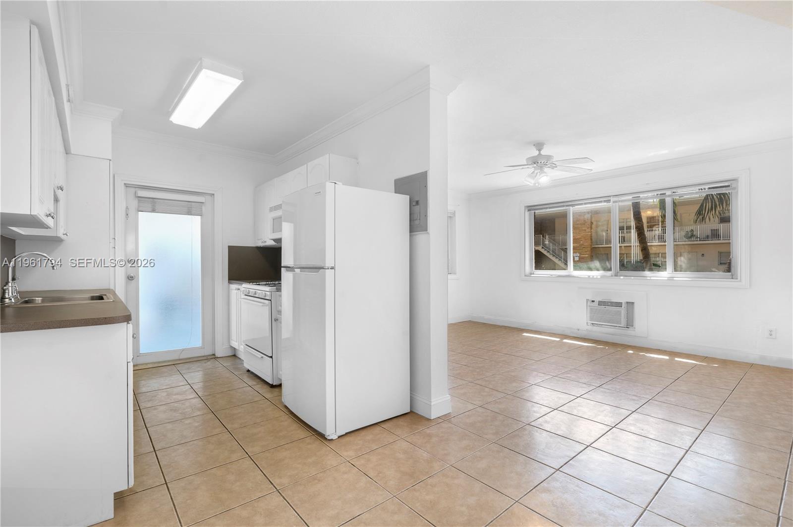315 69th Street, Unit 112 Miami Beach, FL 33141 - Photo 6 of 20 a kitchen with a refrigerator a stove top oven and a refrigerator