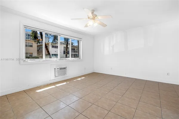 an empty room with windows and ceiling fan