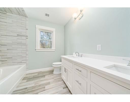 a spacious bathroom with a double vanity sink a toilet and a bathtub