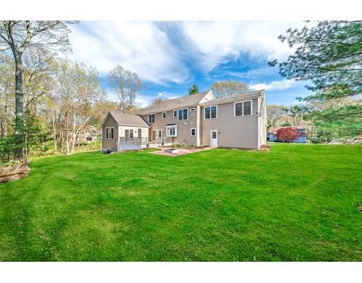 a view of a house with a big yard and large trees