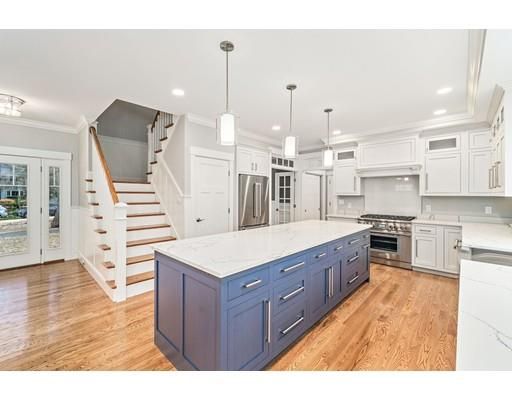 a large kitchen with cabinets wooden floor and stainless steel appliances