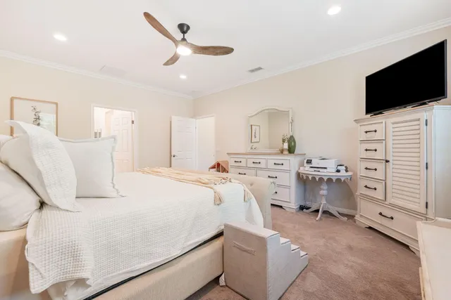 a bedroom with a bed and a flat tv screen on the dresser