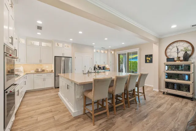 an open kitchen with white cabinets and stainless steel appliances
