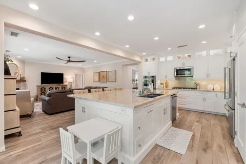 a kitchen with stainless steel appliances kitchen island granite countertop a sink and a stove