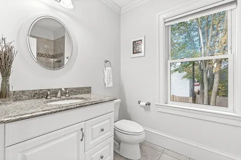 a bathroom with a granite countertop toilet a sink and a mirror