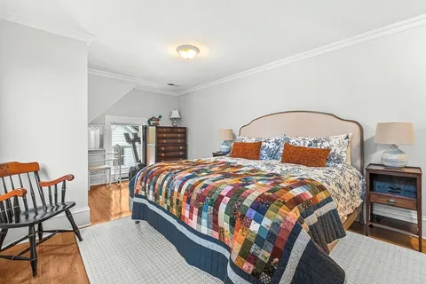 a bedroom with a large bed and two windows