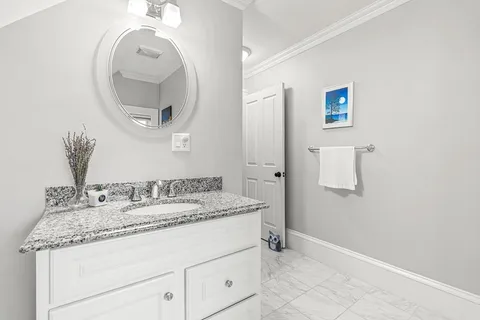 a bathroom with a granite countertop sink and a mirror