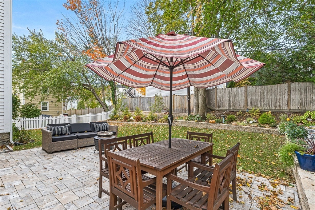 209 Washington Street, Unit 209 Winchester, MA 01890 - Photo 29 of 35 a view of a patio with table and chairs potted plants and a large tree