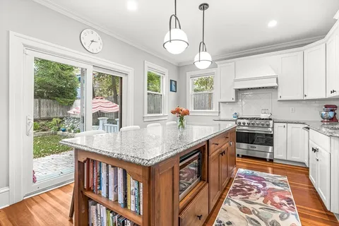 a kitchen with stainless steel appliances granite countertop a stove a sink and a wooden floors