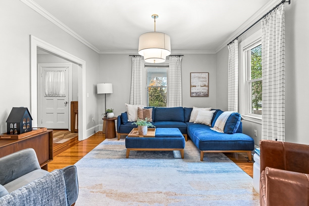 209 Washington Street, Unit 209 Winchester, MA 01890 - Photo 8 of 35 a living room with furniture a large window and a chandelier