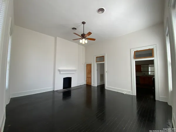 an empty room with windows and a fireplace