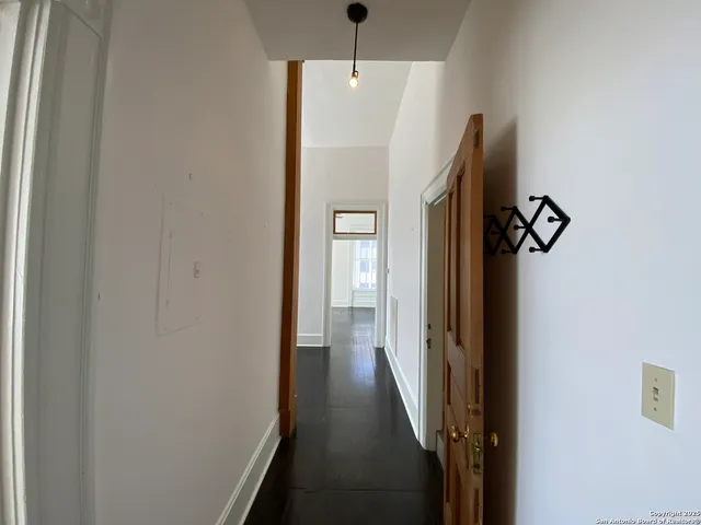 a view of a hallway with wooden floor and staircase