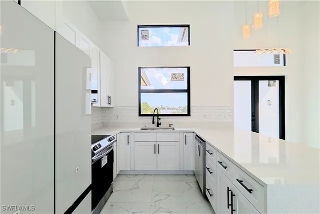 a kitchen with granite countertop a sink stove and cabinets