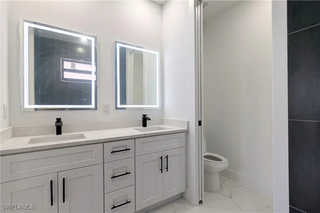 a bathroom with a toilet sink a mirror and