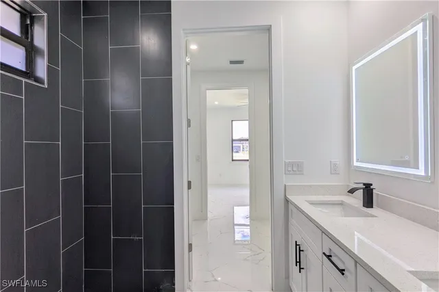 a bathroom with a shower sink and mirror