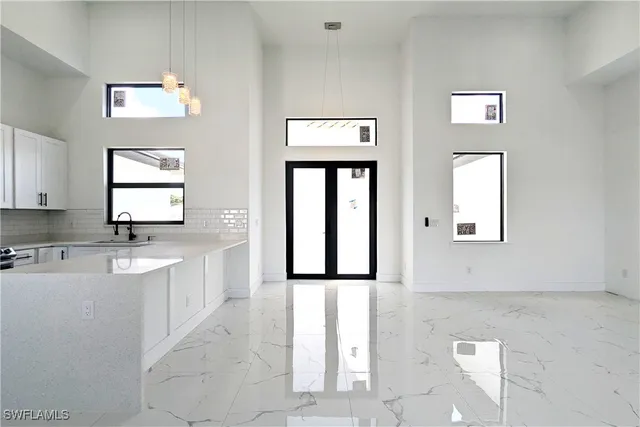 a hallway with a white cabinets and a window