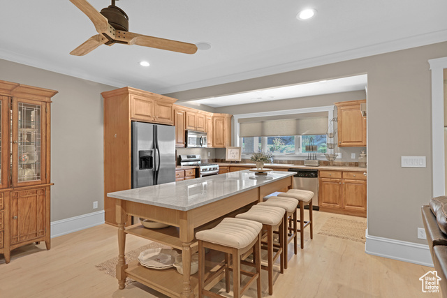 165 East 1550th South Perry, UT 84302 - Photo 22 of 26 Downstairs, secondary, kitchen featuring a breakfast bar area, appliances with stainless steel finishes, light stone countertops, light brown cabinetry, and light wood-type flooring