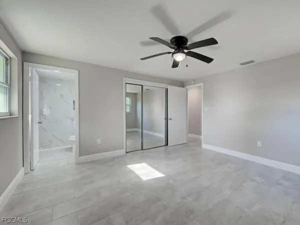 a spacious bedroom with a bed and a chandelier