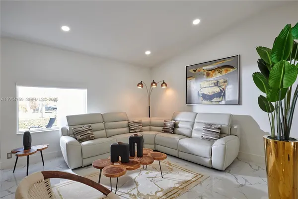 a living room with furniture potted plant and a window