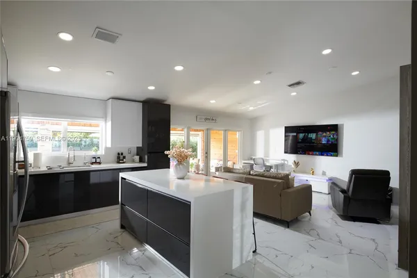 a large white kitchen with a large window